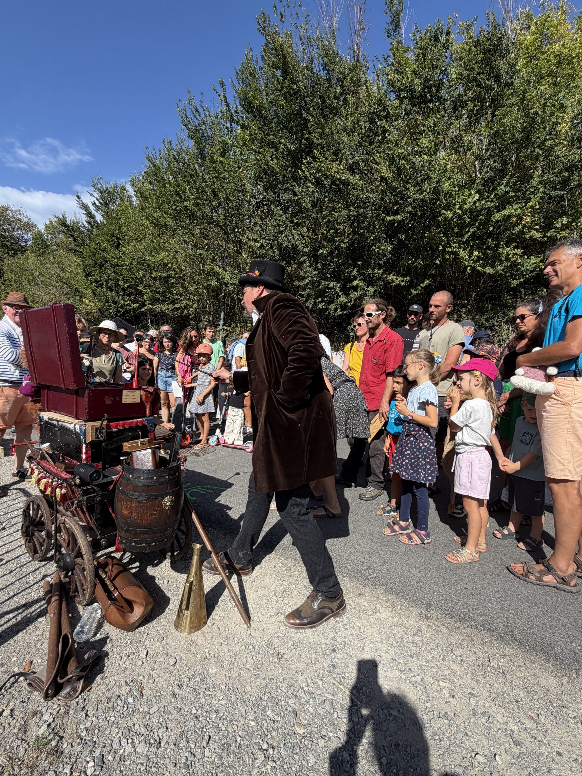 Vitalis en représentation avec sa roulotte du Cirque à Puces devant un public attentif