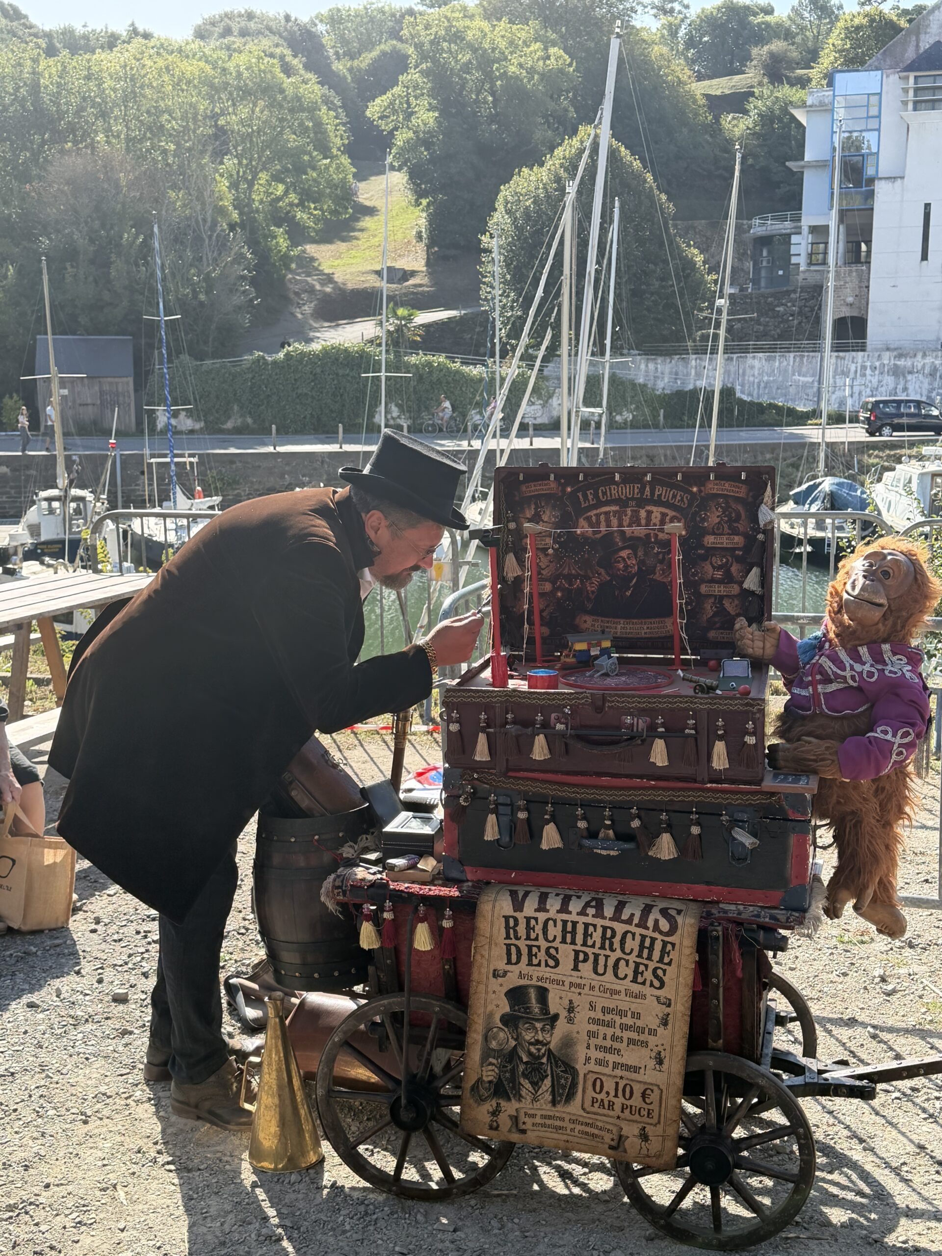 Vitalis en haut-de-forme avec la mascotte du Cirque à Puces sur sa roulotte d'époque